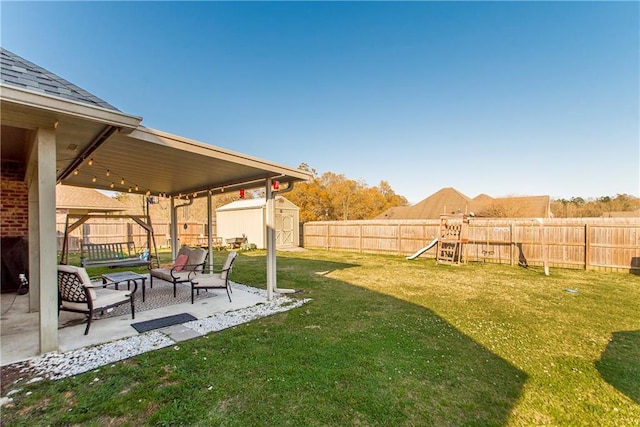 view of yard with a playground, a storage shed, a patio area, a fenced backyard, and an outdoor structure