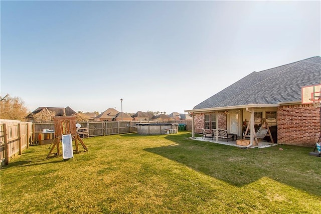 view of yard with a patio area, a fenced backyard, a playground, and a fenced in pool