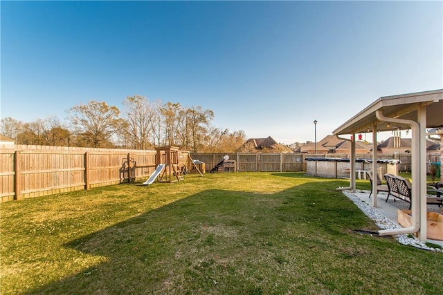 view of yard featuring a patio area, a fenced backyard, a playground, and a fenced in pool