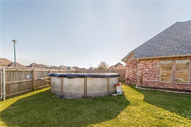 view of yard with a fenced in pool and fence