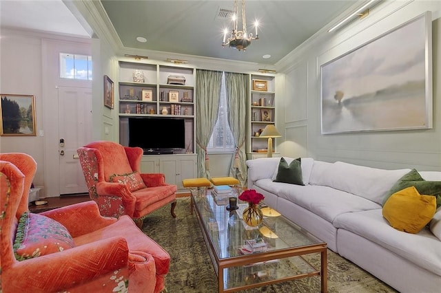 living room featuring ornamental molding, a chandelier, built in features, and a decorative wall