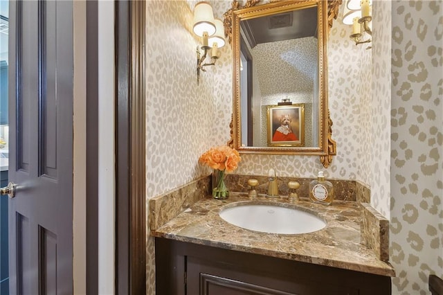 bathroom with vanity and wallpapered walls