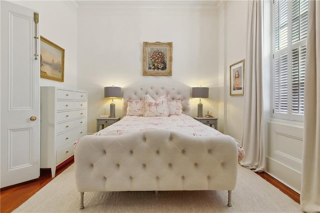 bedroom featuring ornamental molding and dark wood-type flooring