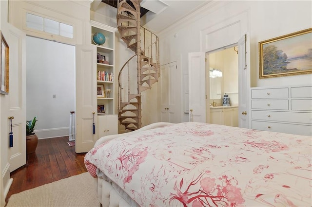 bedroom with ensuite bath, dark wood finished floors, and crown molding