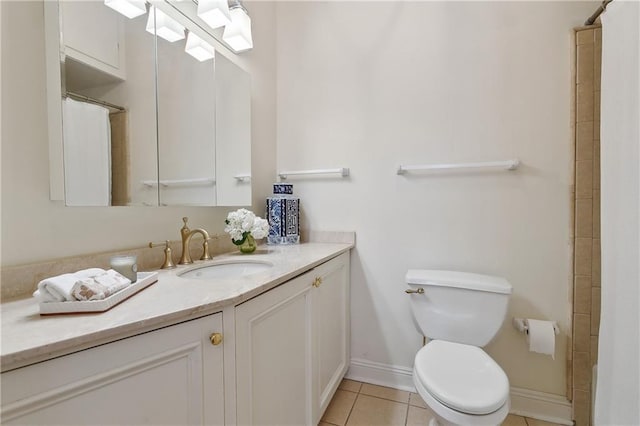 full bath with toilet, vanity, baseboards, and tile patterned floors