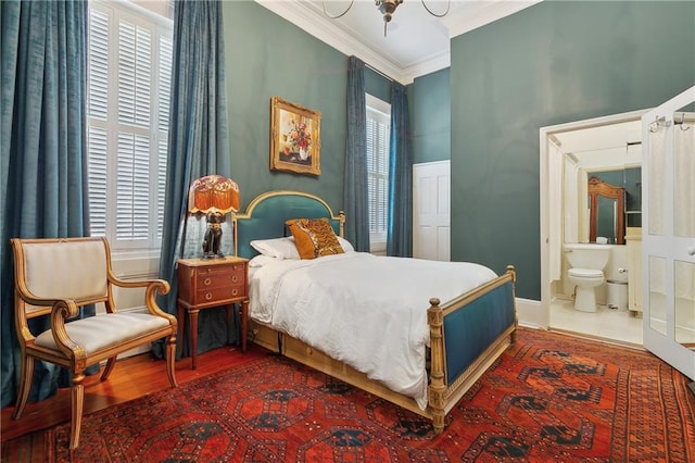 bedroom featuring connected bathroom, crown molding, and wood finished floors