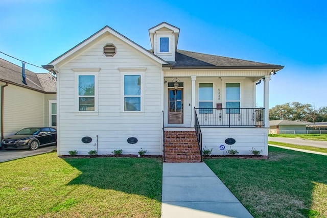 bungalow featuring roof with shingles, a porch, and a front lawn