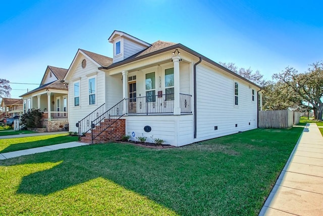 bungalow featuring covered porch, a front yard, and fence