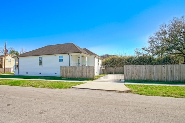 view of property exterior with a fenced front yard and a gate