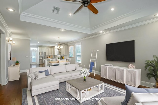 living area with dark wood finished floors, recessed lighting, visible vents, ornamental molding, and baseboards