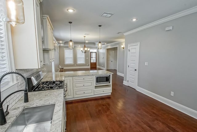 kitchen with tasteful backsplash, visible vents, ornamental molding, stainless steel appliances, and a sink