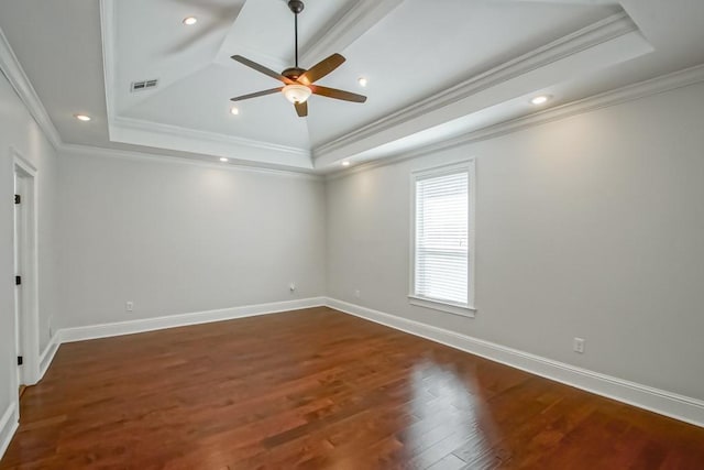 unfurnished room with baseboards, visible vents, a tray ceiling, and wood finished floors