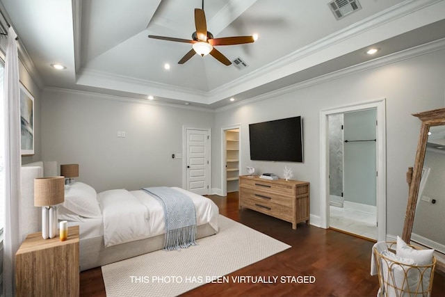 bedroom with a tray ceiling, dark wood-style flooring, visible vents, and recessed lighting