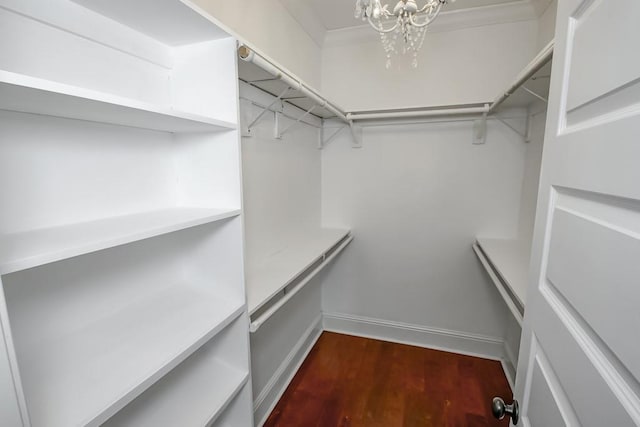 walk in closet featuring a chandelier and wood finished floors