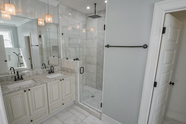 full bathroom featuring marble finish floor, ornamental molding, a sink, and a shower stall