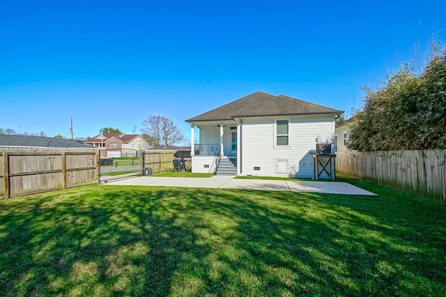 back of property with a fenced backyard and a yard