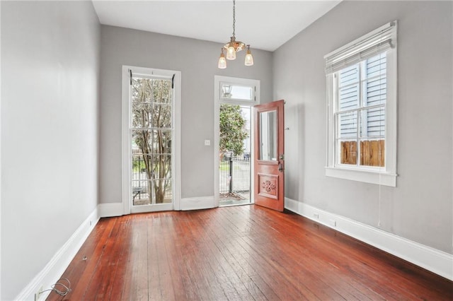 doorway to outside featuring baseboards and hardwood / wood-style floors