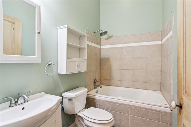 bathroom with toilet, tiled shower / bath, and vanity