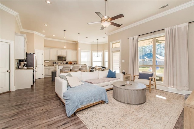 living room featuring ceiling fan, recessed lighting, dark wood-type flooring, visible vents, and crown molding