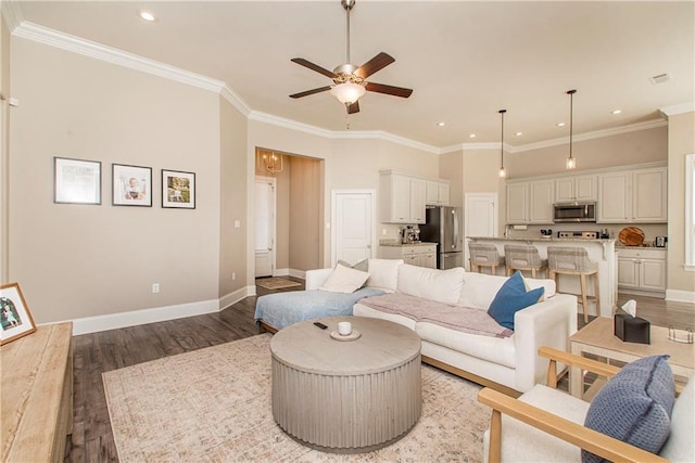 living room with baseboards, a ceiling fan, crown molding, light wood-style floors, and recessed lighting