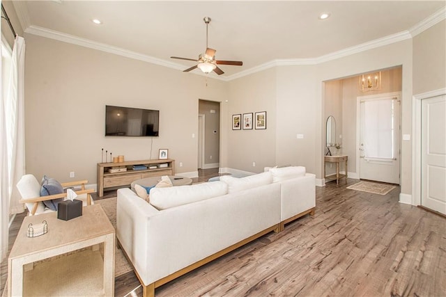 living room featuring light wood-style flooring, ornamental molding, baseboards, and recessed lighting