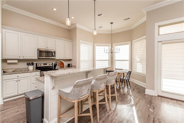 kitchen featuring crown molding, light wood finished floors, stainless steel appliances, visible vents, and white cabinets