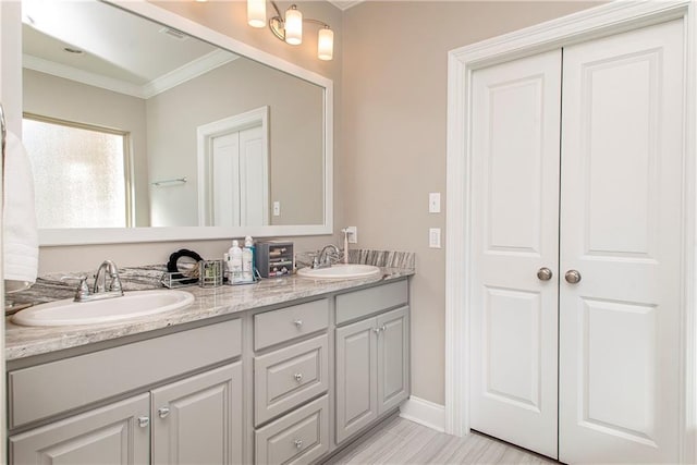 full bath featuring double vanity, visible vents, ornamental molding, and a sink