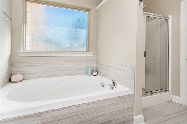 full bathroom with a bath, a stall shower, and a wealth of natural light