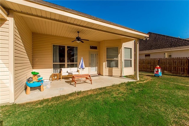 rear view of house featuring a patio, outdoor lounge area, a lawn, ceiling fan, and fence