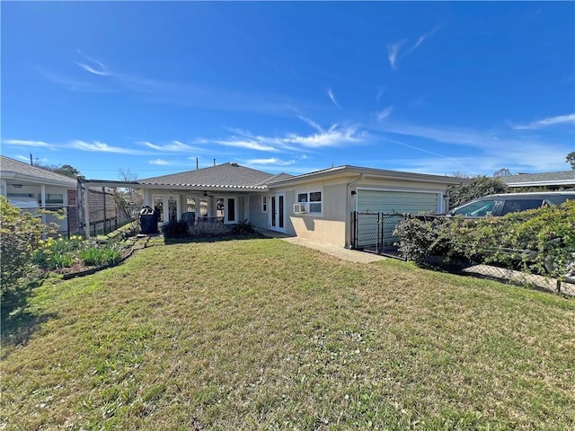 rear view of house featuring a yard, an attached garage, and fence