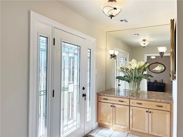 foyer with light tile patterned floors and visible vents