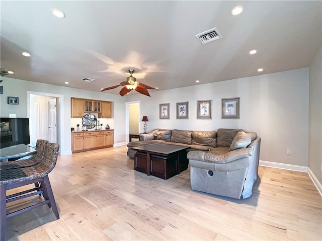 living room with light wood-style flooring, visible vents, and recessed lighting