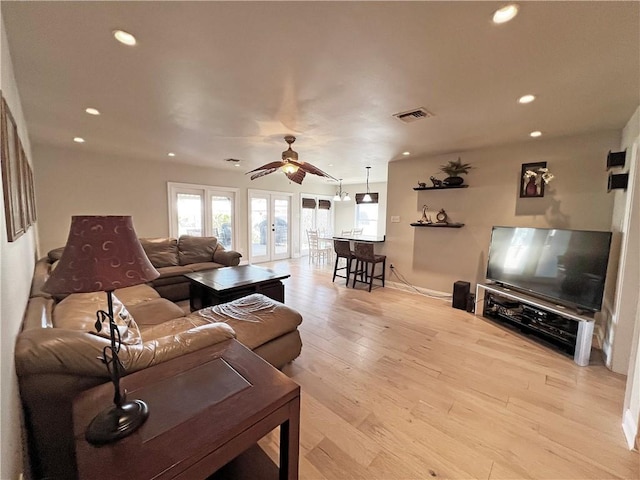 living room with recessed lighting, french doors, visible vents, and light wood-style flooring