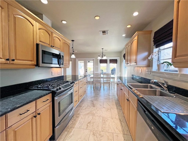 kitchen with recessed lighting, stainless steel appliances, a sink, visible vents, and dark stone countertops