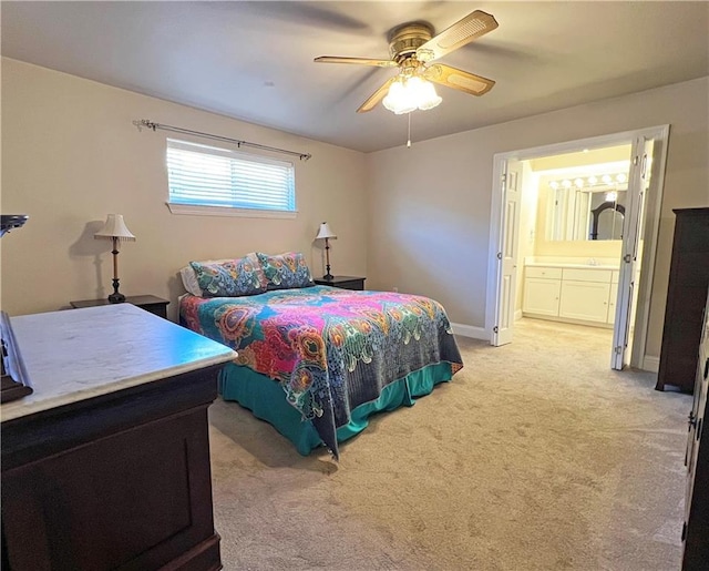 bedroom with light carpet, ceiling fan, ensuite bath, and baseboards