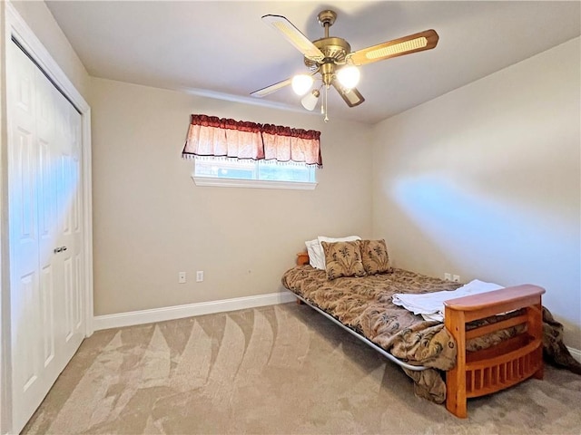 carpeted bedroom with a closet, a ceiling fan, and baseboards