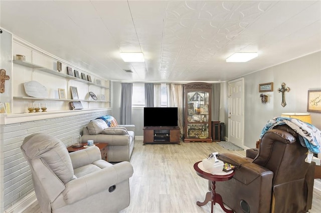 living room featuring visible vents, baseboards, and wood finished floors