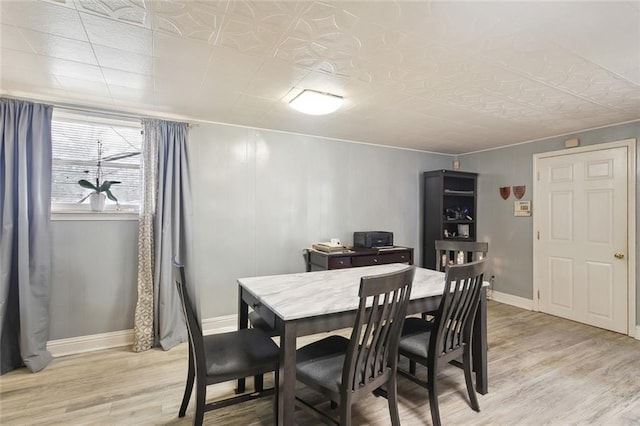 dining room featuring light wood-type flooring and baseboards