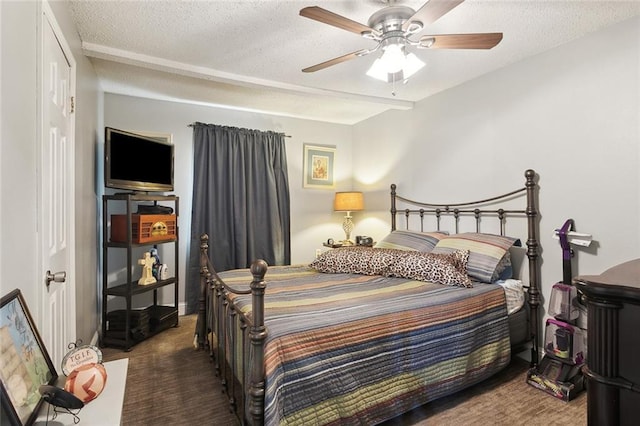 carpeted bedroom featuring ceiling fan and a textured ceiling