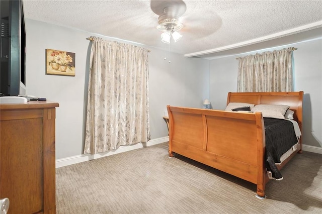 bedroom featuring a textured ceiling, carpet flooring, a ceiling fan, and baseboards