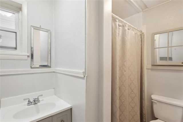 full bath with a shower with curtain, vanity, and toilet