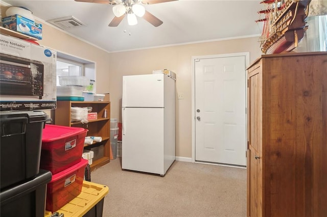 kitchen featuring ornamental molding, freestanding refrigerator, visible vents, and ceiling fan