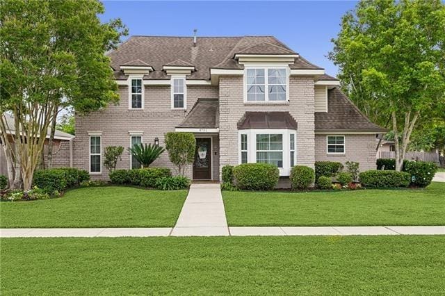 view of front of home featuring a front lawn and brick siding