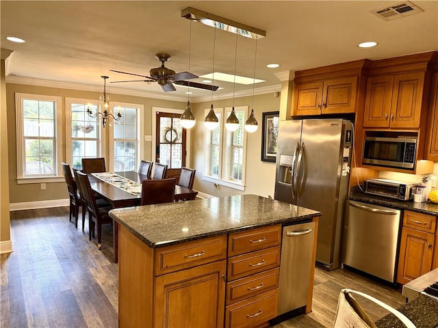 4701 Lake Vista Dr, Metairie, LA 70006 - kitchen featuring stainless steel appliances, brown cabinets, ceiling fan, healthy amount of natural light, and ornamental molding