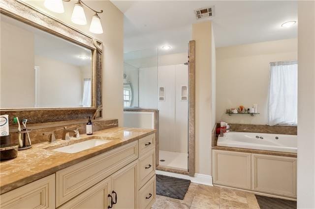 bathroom featuring a stall shower, visible vents, a garden tub, and vanity