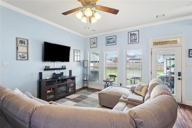 living room with baseboards, visible vents, a ceiling fan, ornamental molding, and wood finished floors