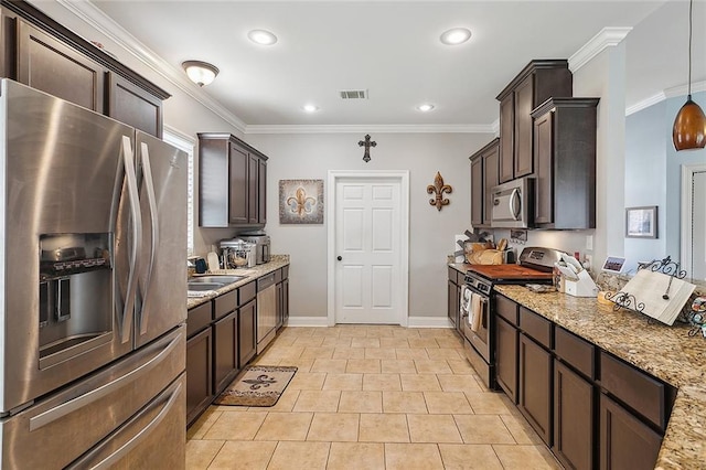 kitchen featuring dark brown cabinetry, appliances with stainless steel finishes, light stone counters, and ornamental molding