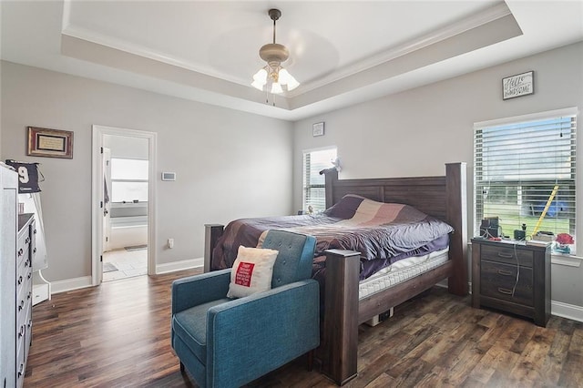 bedroom with multiple windows, a raised ceiling, and dark wood finished floors