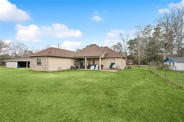 rear view of house with a patio, brick siding, a lawn, and fence