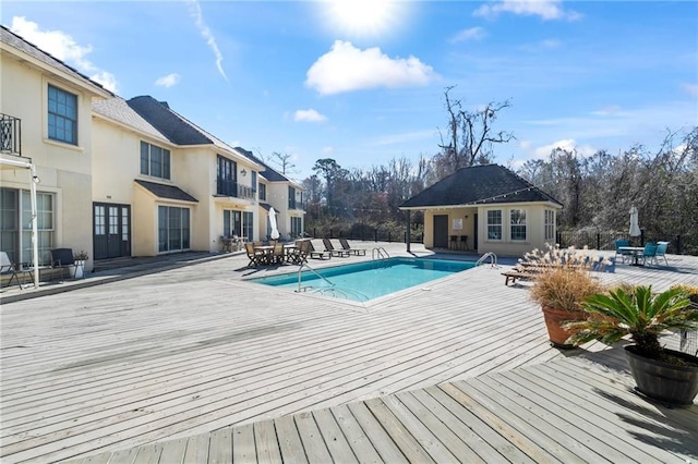 pool with a patio area, a storage structure, an outdoor structure, and a wooden deck